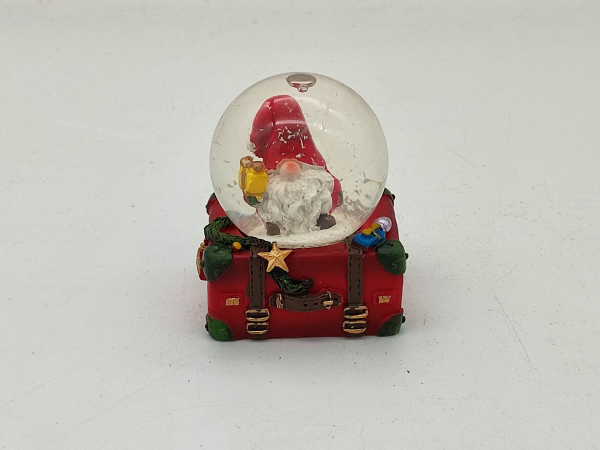 Snow globe gnome on suitcase with gift